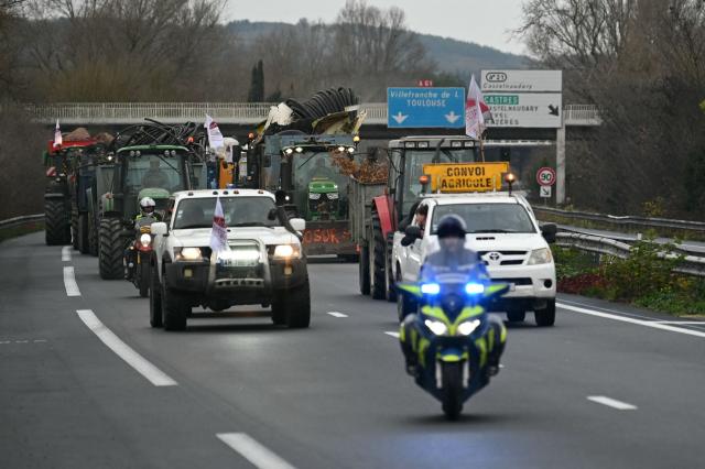 Farmers from the Young Farmers (JA - Jeunes Agriculteurs) union drive tractors and agricultural vehicles to Carcassone on the A61 motorway, in Castelnaudary, southwestern France, on December 17, 2025, as part of a nationwide action by farmers to protest against the government's mandatory culling protocol for cattle herds affected by lumpy skin disease (dermatose nodulaire contagieuse). The viral disease first detected in France in June 2025 that has led to the slaughter of over 3,000 cattle across more than 110 outbreaks nationwide. (Photo by Matthieu RONDEL / AFP)