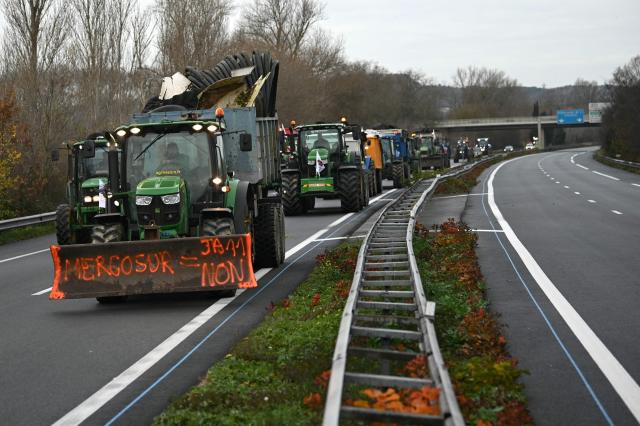 Farmers from the Young Farmers (JA - Jeunes Agriculteurs) union drive tractors and agricultural vehicles to Carcassone on the A61 motorway, in Castelnaudary, southwestern France, on December 17, 2025, as part of a nationwide action by farmers to protest against the government's mandatory culling protocol for cattle herds affected by lumpy skin disease (dermatose nodulaire contagieuse). The viral disease first detected in France in June 2025 that has led to the slaughter of over 3,000 cattle across more than 110 outbreaks nationwide. (Photo by Matthieu RONDEL / AFP)