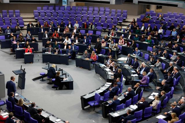 An general overview shows German Chancellor Friedrich Merz (L) as he addresses parliamentarians and answers questions of parlamentarians at the Bundestag (lower house of parliament) in Berlin, on December 17, 2025. (Photo by Odd ANDERSEN / AFP)