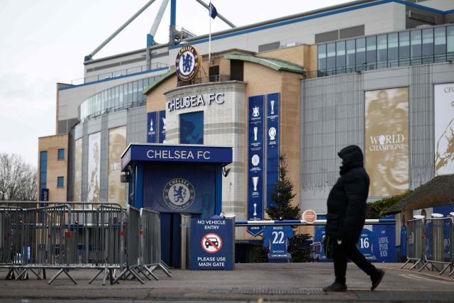 A pedestrian walks outside the grounds of Stamford Bridge, the home of English Premier League team Chelsea, formally owned by Russian businessman Roman Abramovich, in London on December 17, 2025. Britain's Prime Minister Keir Starmer on December 17, 2025 warned former Chelsea owner Roman Abramovich "the clock is ticking" over the frozen £2.5 billion (3.4 billion USD) generated from the sale of the club, which has been earmarked to help Ukraine's war victims. A consortium led by US businessman Todd Boehly bought the Premier League giants after Abramovich was sanctioned following Russian President Vladimir Putin's invasion of Ukraine. (Photo by HENRY NICHOLLS / AFP)