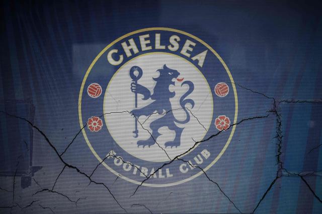 The logo for English Premier League team Chelsea, formally owned by Russian businessman Roman Abramovich, is pictured outside the grounds of Stamford Bridge in London on December 17, 2025. Britain's Prime Minister Keir Starmer on December 17, 2025 warned former Chelsea owner Roman Abramovich "the clock is ticking" over the frozen £2.5 billion (3.4 billion USD) generated from the sale of the club, which has been earmarked to help Ukraine's war victims. A consortium led by US businessman Todd Boehly bought the Premier League giants after Abramovich was sanctioned following Russian President Vladimir Putin's invasion of Ukraine. (Photo by HENRY NICHOLLS / AFP)
