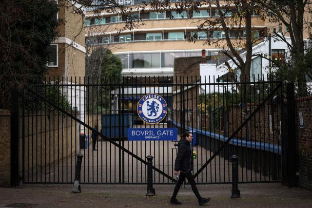 A woman walks outside the grounds of Stamford Bridge, the home of English Premier League team Chelsea, formally owned by Russian businessman Roman Abramovich, in London on December 17, 2025. Britain's Prime Minister Keir Starmer on December 17, 2025 warned former Chelsea owner Roman Abramovich "the clock is ticking" over the frozen £2.5 billion (3.4 billion USD) generated from the sale of the club, which has been earmarked to help Ukraine's war victims. A consortium led by US businessman Todd Boehly bought the Premier League giants after Abramovich was sanctioned following Russian President Vladimir Putin's invasion of Ukraine. (Photo by HENRY NICHOLLS / AFP)