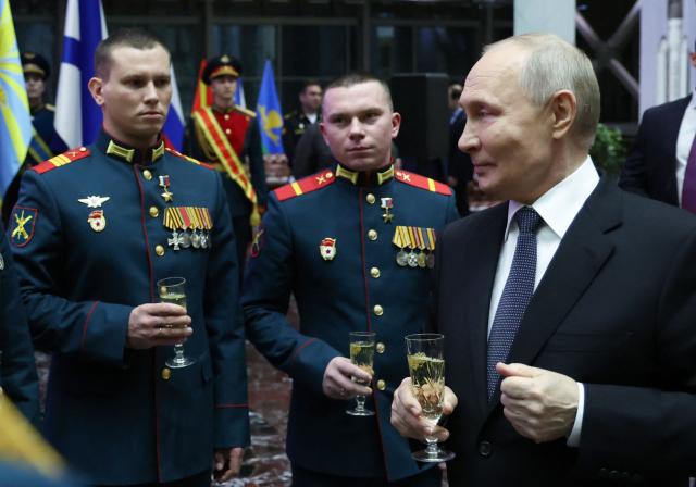 In this pool photograph distributed by the Russian state agency Sputnik, Russia's President Vladimir Putin meets with service members awarded with Gold Star medal of Hero of Russia after an expanded meeting of the Russian Defence Ministry Board at the National Defence Control Centre in Moscow on December 17, 2025. (Photo by Alexander KAZAKOV / POOL / AFP)