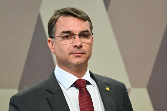 Senator Flavio Bolsonaro, son of former President Jair Bolsonaro, attends a session of the committee discussing the bill that reduces the sentences of those convicted of attempted coup d'etat in Brasilia, on December 17, 2025. Brazil's Senate is debating a bill passed by the lower house of Congress that could slash the jail term of former president Jair Bolsonaro, a move that sparked nationwide protests over the weekend. (Photo by Evaristo Sa / AFP)