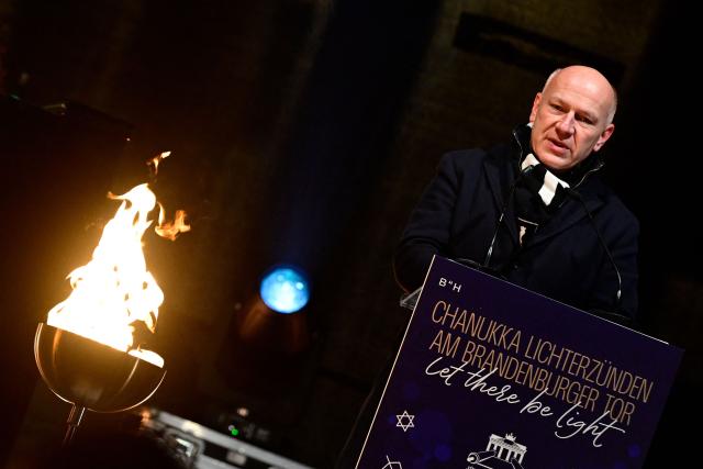 Berlin Mayor Kai Wegner addresses guests during the central Hanukkah candle lighting ceremony at the Brandenburg Gate in Berlin on December 17, 2025. (Photo by John MACDOUGALL / AFP)