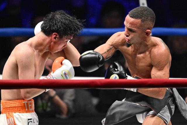Japan's Kyosuke Takami (L) and Puerto Rico's Rene Santiago fight during the WBA and WBO light flyweight unification match at Ryogoku Kokugikan in Tokyo on December 17, 2025. (Photo by Kazuhiro NOGI / AFP)
