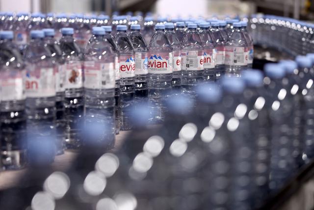 This photograph shows bottles of Evian on an assembly line at the Evian water bottling plant, in Publier, eastern France on December 16, 2025. (Photo by Alex MARTIN / AFP)