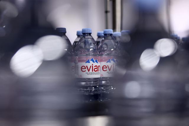 This photograph shows bottles of Evian on an assembly line at the Evian water bottling plant, in Publier, eastern France on December 16, 2025. (Photo by Alex MARTIN / AFP)