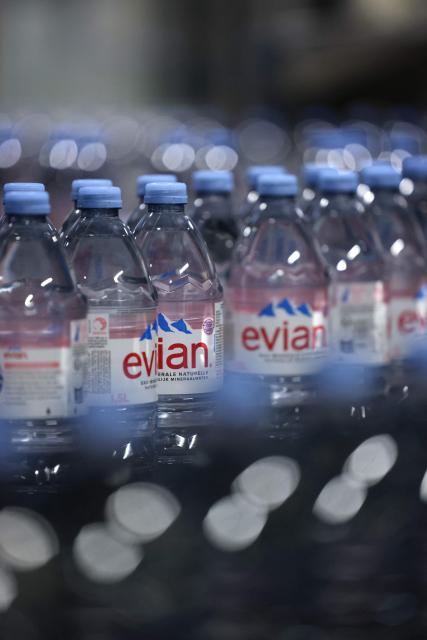 This photograph shows bottles of Evian on an assembly line at the Evian water bottling plant, in Publier, eastern France on December 16, 2025. (Photo by Alex MARTIN / AFP)