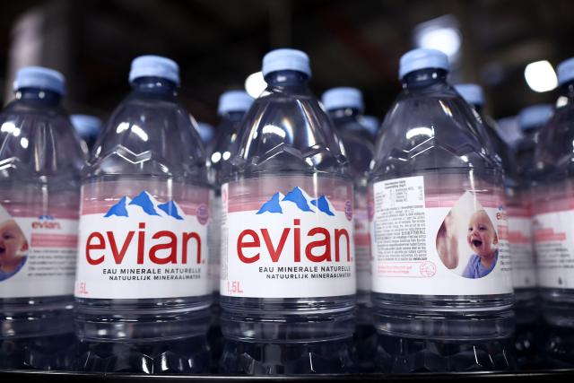 This photograph shows bottles of Evian on an assembly line at the Evian water bottling plant, in Publier, eastern France on December 16, 2025. (Photo by Alex MARTIN / AFP)