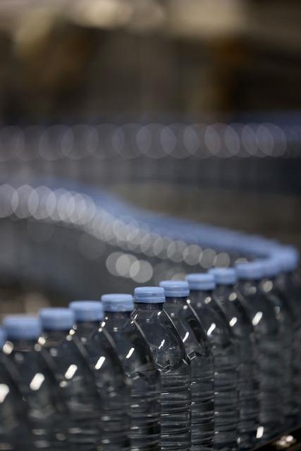 This photograph shows bottles of Evian on an assembly line at the Evian water bottling plant, in Publier, eastern France on December 16, 2025. (Photo by Alex MARTIN / AFP)