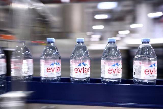 This photograph shows bottles of Evian on an assembly line at the Evian water bottling plant, in Publier, eastern France on December 16, 2025. (Photo by Alex MARTIN / AFP)