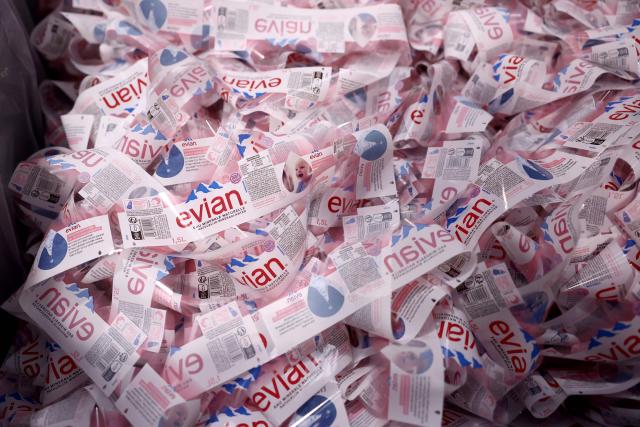 This photograph shows bottle labels of Evian on an assembly line at the Evian water bottling plant, in Publier, eastern France, on December 16, 2025. (Photo by Alex MARTIN / AFP)