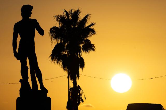 This photograph taken in the eighth arrondissement of Marseille, southeastern France on December 17, 2025 shows a copy of the statue of Michelangelo's David in Carrara marble at sunset. (Photo by MIGUEL MEDINA / AFP)