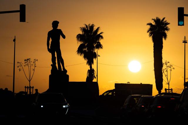 This photograph taken in the eighth arrondissement of Marseille, southeastern France on December 17, 2025 shows a copy of the statue of Michelangelo's David in Carrara marble at sunset. (Photo by MIGUEL MEDINA / AFP)