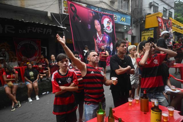 Flamengo supporters react as they watch the final match of 2025 FIFA Intercontinental Cup between Paris Saint-Germain and Flamengo at Rocinha favela in Rio de Janeiro, Brazil on December 17, 2025. (Photo by MAURO PIMENTEL / AFP)