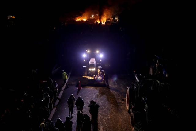 Protesters block the A61 motorway near Carcassonne as part of a nationwide action by farmers to protest against the government's mandatory culling protocol for cattle herds affected by lumpy skin disease (dermatose nodulaire contagieuse), in Carcassonne, southern France, on December 17, 2025. The viral disease first detected in France in June 2025 that has led to the slaughter of over 3,000 cattle across more than 110 outbreaks nationwide. (Photo by Valentine CHAPUIS / AFP)