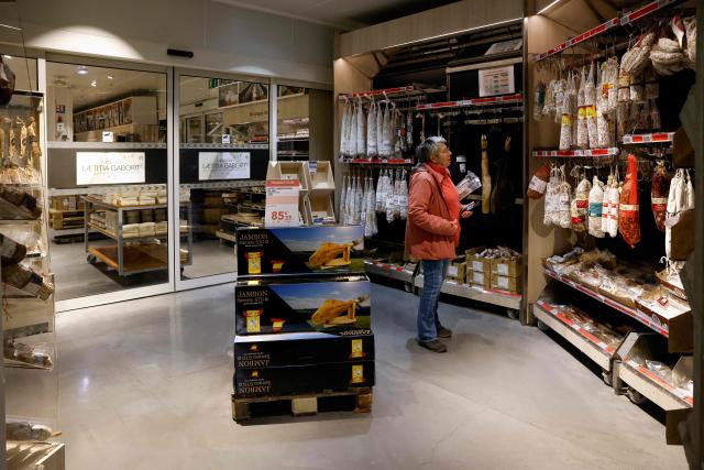 A customer looks at charcuterie products at the multinational wholesale chain 'Metro' flagship store in Nanterre during a press visit, in western Paris, on December 17, 2025. (Photo by Charlotte SIEMON / AFP)