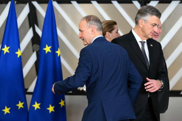 Ireland's Prime Minister Micheal Martin (L) and Croatia's Prime Minister Andrej Plenkovic leave after a family photograph as part of the EU Western Balkans summit in Brussels on December 17, 2025. (Photo by NICOLAS TUCAT / AFP)