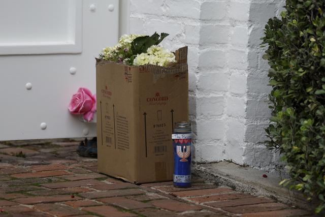 Flowers and candles sit outside US actor and director Rob Reiner's mansion in the Brentwood neighborhood of Los Angeles, California, on  December 17, 2025 in Los Angeles, California. The son of famed Hollywood director Rob Reiner was charged with two counts of first-degree murder over the brutal slaying of his parents, the chief prosecutor of Los Angeles said on December 16. Rob Reiner, 78, and his wife Michele Singer Reiner, 70, were found dead in their home on December 15, 2025. (Photo by Caroline Brehman / AFP)