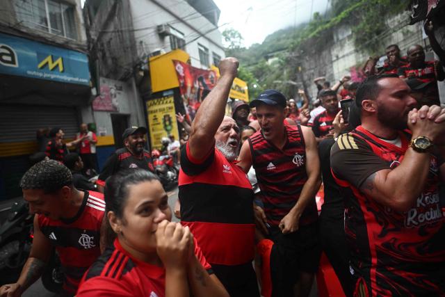 Flamengo fans react while watching the final match of the 2025 FIFA Intercontinental Cup between Paris Saint-Germain and Flamengo at Rocinha favela in Rio de Janeiro, Brazil, on December 17, 2025. (Photo by MAURO PIMENTEL / AFP)