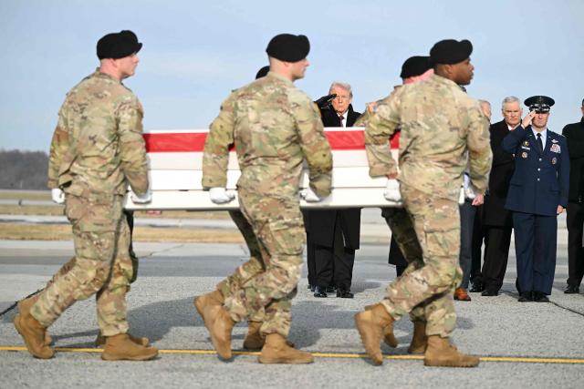 US President Donald Trump salutes the transfer case of Iowa National Guard Sgt. Edgar Torres Tovar as it is carried past him during a ceremony for the return of the remains of two Iowa National Guard members and a civilian translator killed in an attack in Syria at Dover Air Force Base in Delaware on December 17, 2025. (Photo by ANDREW CABALLERO-REYNOLDS / AFP)