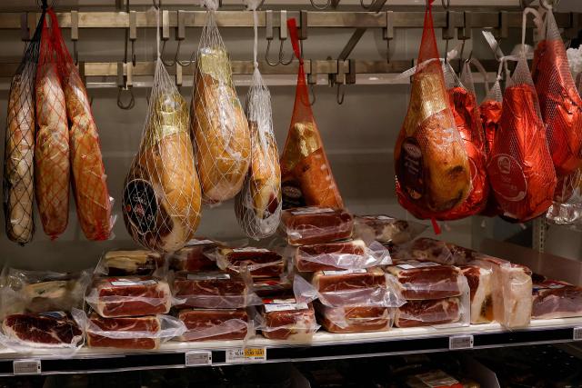 This photograph shows Serrano hams displayed at the charcuterie department in the multinational wholesale chain 'Metro' flagship store in Nanterre during a press visit, in western Paris, on December 17, 2025. (Photo by Charlotte SIEMON / AFP)