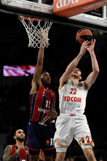AS Monaco's US guard #22 Terry Tarpey goes up for a shot defended by Baskonia's US guard #11 Trent Forrest during the Euroleague basketball match between Baskonia Vitoria-Gasteiz and Monaco at Buesa Arena in Vitoria, on December 17, 2025. (Photo by ANDER GILLENEA / AFP)