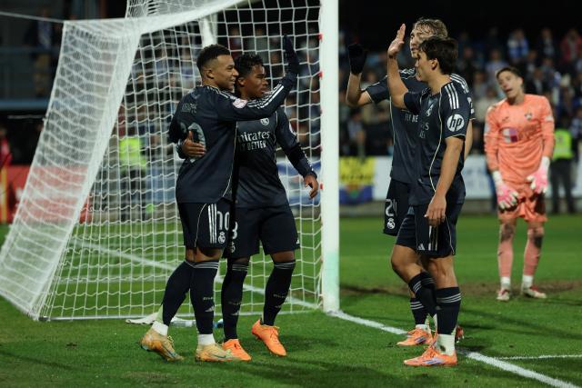 Real Madrid's French forward #10 Kylian Mbappe (L) and teammates celebrate after Talavera's own goal during the Spanish Copa del Rey (King's Cup) round of 32 second leg football match between Talavera CF and Real Madrid CF at El Prado Municipal Stadium in Talavera de la Reina on December 17, 2025. (Photo by Thomas COEX / AFP)