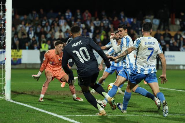 Real Madrid's French forward #10 Kylian Mbappe (back) fights for the ball before Talavera's own goal during the Spanish Copa del Rey (King's Cup) round of 32 second leg football match between Talavera CF and Real Madrid CF at El Prado Municipal Stadium in Talavera de la Reina on December 17, 2025. (Photo by Thomas COEX / AFP)