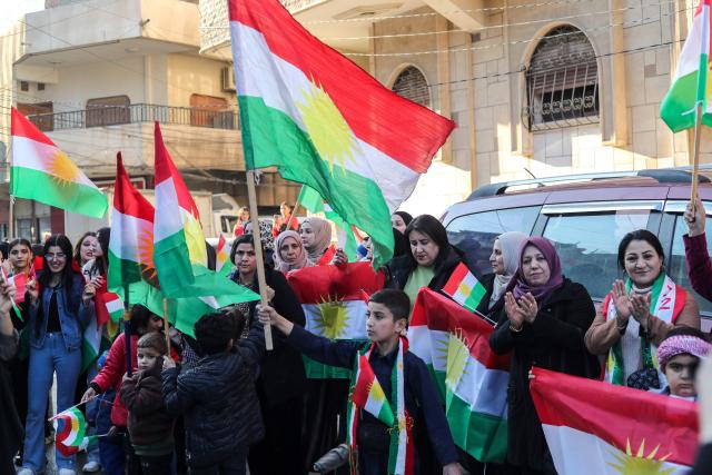 Syrian Kurds wave national flags as they celebrate Kurdish Flag Day in the city of Qamishli in northeastern Syria on December 17, 2025. (Photo by Delil SOULEIMAN / AFP)