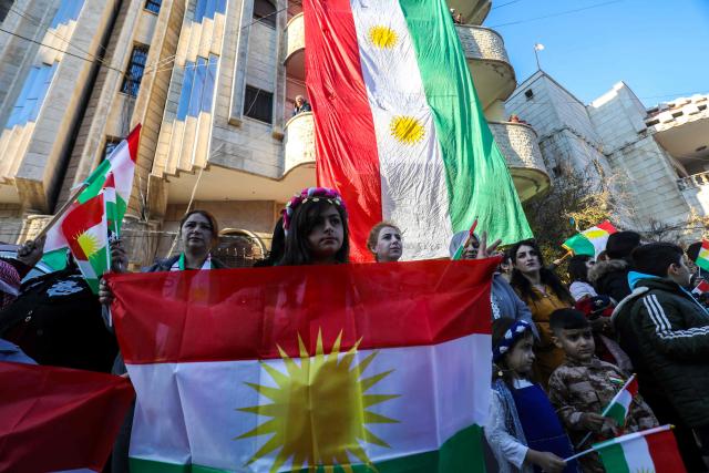 Syrian Kurds wave national flags as they celebrate Kurdish Flag Day in the city of Qamishli in northeastern Syria on December 17, 2025. (Photo by Delil SOULEIMAN / AFP)