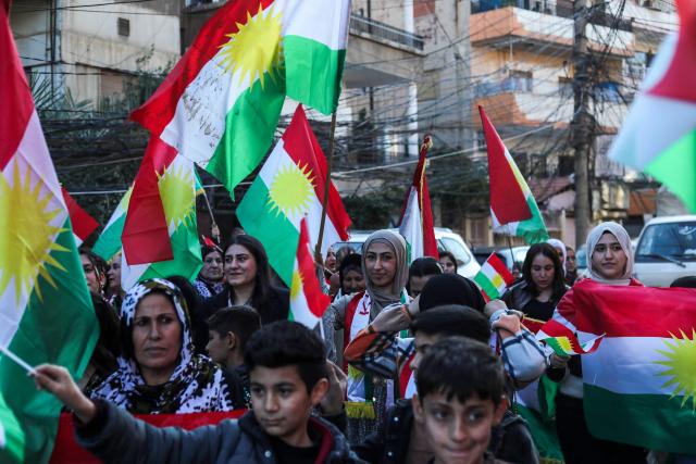 Syrian Kurds wave national flags as they celebrate Kurdish Flag Day in the city of Qamishli in northeastern Syria on December 17, 2025. (Photo by Delil SOULEIMAN / AFP)