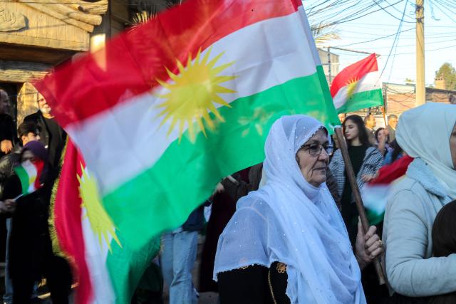 Syrian Kurds wave national flags as they celebrate Kurdish Flag Day in the city of Qamishli in northeastern Syria on December 17, 2025. (Photo by Delil SOULEIMAN / AFP)