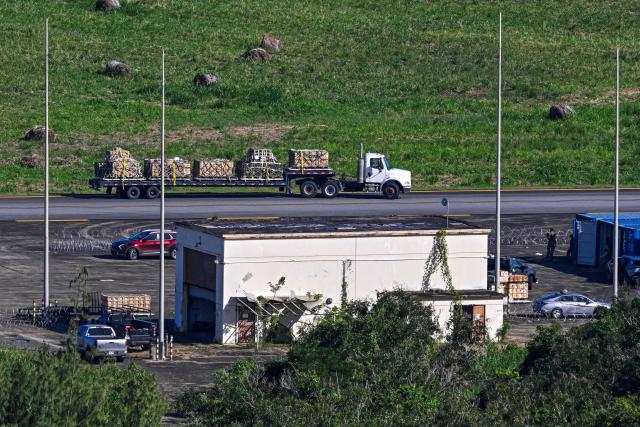 A truck moves equipment at José Aponte de la Torre Airport, formerly Roosevelt Roads Naval Station, on December 17, 2025 in Ceiba, Puerto Rico. Aircraft movements and coordinated exercises were observed throughout the day as part of heightened regional military readiness linked to ongoing operations at US military bases and maritime security efforts in the Caribbean. President Donald Trump administration is conducting a military campaign in the Caribbean and eastern Pacific, deploying naval and air forces for what it calls an anti-drugs offensive. (Photo by Miguel J. Rodriguez Carrillo / AFP)