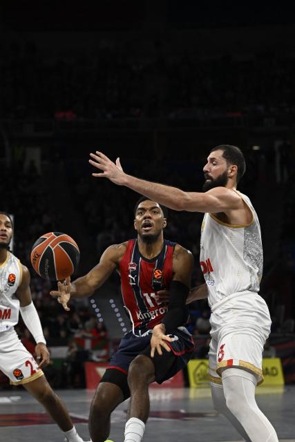 Baskonia's US guard #11 Trent Forrest fights for the ball with AS Monaco's Spanish centre #33 Nikola Mirotic during the Euroleague basketball match between Baskonia Vitoria-Gasteiz and Monaco at Buesa Arena in Vitoria, on December 17, 2025. (Photo by ANDER GILLENEA / AFP)