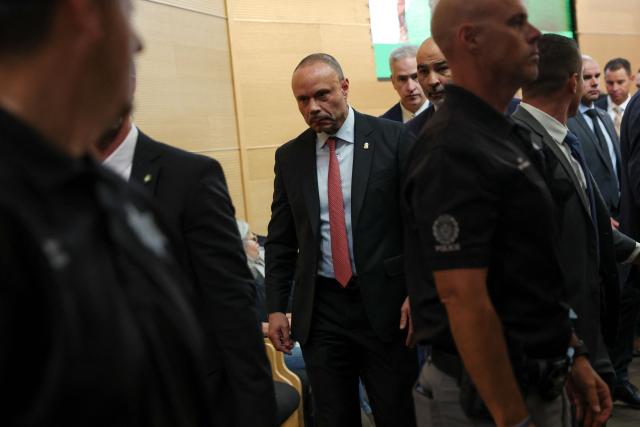 (FILES) Dan Bongino (C), Deputy director of the FBI, after a press conference outside the Doterra Auditorium at Utah Valley University, two days after youth activist and influencer Charlie Kirk was shot during a public event in Orem, Utah, on September 12, 2025. Bongino, a former right-wing podcaster, announced on December 17, 2025 that he would step down in January after less than 10 months on the job. The 51-year-old Bongino, in a post on X announcing his resignation, did not give a reason for the move. (Photo by Patrick T. Fallon / AFP)