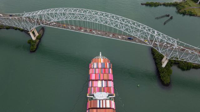 (FILES) This aerial view shows the Taiwanese cargo ship Yang Ming sailing out of the Panama Canal on the Pacific side in Panama City on October 6, 2025. Panama earned record revenue from its interoceanic canal operations last year, marked by a recovery in transits following a drought, the canal authority reported on December 17, 2025. (Photo by MARTIN BERNETTI / AFP)