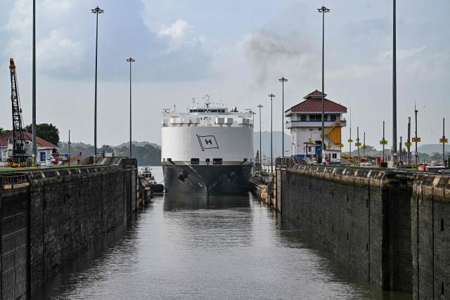 (FILES) A car carrier ship sails through the Pedro Miguel Locks during maintenance work at the Panama Canal, on the outskirts of Panama City on May 30, 2025. Panama earned record revenue from its interoceanic canal operations last year, marked by a recovery in transits following a drought, the canal authority reported on December 17, 2025. (Photo by MARTIN BERNETTI / AFP)