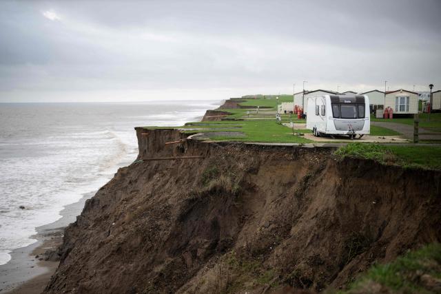 A photograph taken on November 13, 2025 shows the Cliff Top Caravan Park, near the village of Atwick, on the North sea coast in an area which is experiencing intense coastal erosion, near Bridlington, in the East Riding of Yorkshire, north eastern England. The Holderness coastline, covering 61km between the Spurn nature reserve in the south and Flamborough in the north, experiences one of the fastest rates of erosion in Europe. The Holderness cliffs are eroding at average rate of around 1.5 metres per year, although individual cliff losses can exceed 20 metres per year. Over the last 1000 years, the coast has retreated by around 2 kilometres, resulting in the destruction of 26 villages listed in the Domesday survey of 1086. (Photo by Oli SCARFF / AFP)