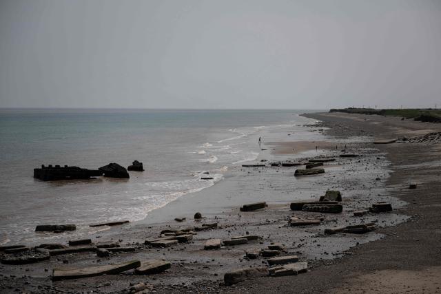 A photograph taken on June 17, 2025 shows the remnants of the Godwin Artillery Battery, initially constructed on the cliff top in 1915, but now located on the beach following intense coastal erosion, near the village of Kilnsea, near Withernsea, in the East Riding of Yorkshire, north eastern England. The Holderness coastline, covering 61km between the Spurn nature reserve in the south and Flamborough in the north, experiences one of the fastest rates of erosion in Europe. The Holderness cliffs are eroding at average rate of around 1.5 metres per year, although individual cliff losses can exceed 20 metres per year. Over the last 1000 years, the coast has retreated by around 2 kilometres, resulting in the destruction of 26 villages listed in the Domesday survey of 1086. (Photo by Oli SCARFF / AFP)