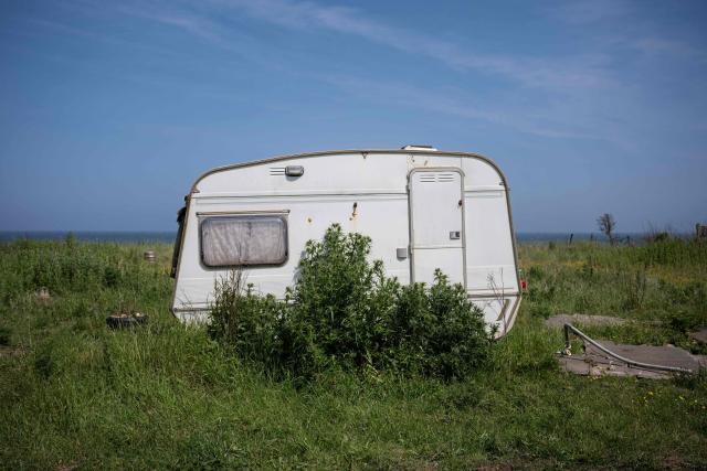 A photograph taken on June 12, 2025 shows a caravan parked adjacent to a cliff on the North Sea coast that is undergoing coastal erosion, near the village of Skipsea, near Hornsea, in the East Riding of Yorkshire, north eastern England. The Holderness coastline, covering 61km between the Spurn nature reserve in the south and Flamborough in the north, experiences one of the fastest rates of erosion in Europe. The Holderness cliffs are eroding at average rate of around 1.5 metres per year, although individual cliff losses can exceed 20 metres per year. Over the last 1000 years, the coast has retreated by around 2 kilometres, resulting in the destruction of 26 villages listed in the Domesday survey of 1086. (Photo by OLI SCARFF / AFP)