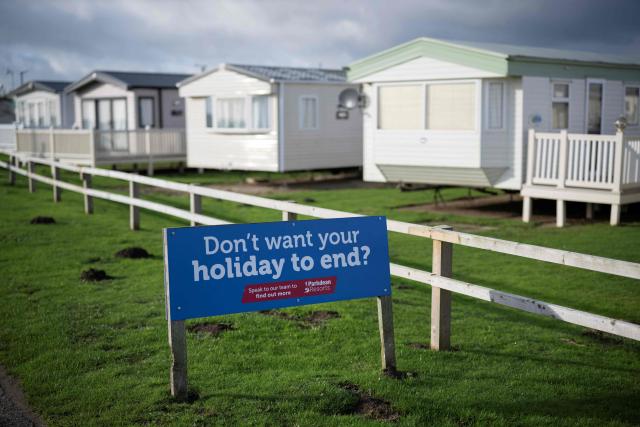 A photograph taken on November 13, 2025 shows a notice promoting Barmston Beach Holiday Park, located on the North sea coast in an area which is experiencing intense coastal erosion, near Bridlington, in the East Riding of Yorkshire, north eastern England. The Holderness coastline, covering 61km between the Spurn nature reserve in the south and Flamborough in the north, experiences one of the fastest rates of erosion in Europe. The Holderness cliffs are eroding at average rate of around 1.5 metres per year, although individual cliff losses can exceed 20 metres per year. Over the last 1000 years, the coast has retreated by around 2 kilometres, resulting in the destruction of 26 villages listed in the Domesday survey of 1086. (Photo by Oli SCARFF / AFP)