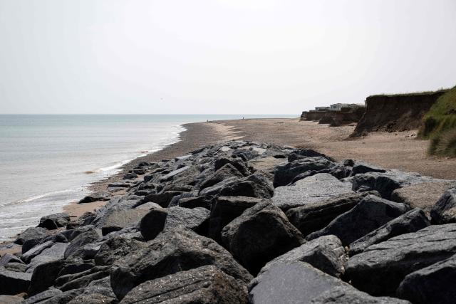 A photograph taken on June 17, 2025 shows sea defences installed adjacent to Easington Gas Terminal in order to mitigate intense coastal erosion, near the village of Easington, near Withernsea, in the East Riding of Yorkshire, north eastern England. The Holderness coastline, covering 61km between the Spurn nature reserve in the south and Flamborough in the north, experiences one of the fastest rates of erosion in Europe. The Holderness cliffs are eroding at average rate of around 1.5 metres per year, although individual cliff losses can exceed 20 metres per year. Over the last 1000 years, the coast has retreated by around 2 kilometres, resulting in the destruction of 26 villages listed in the Domesday survey of 1086. (Photo by Oli SCARFF / AFP)