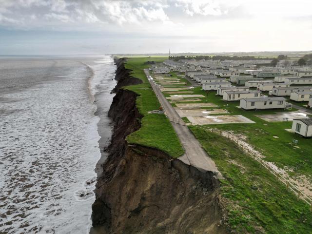 An aerial photograph taken on November 13, 2025 shows a view of the Skirlington Coast holiday park, located on the North sea coast in an area which is experiencing intense coastal erosion, near Hornsea, in the East Riding of Yorkshire, north eastern England. The Holderness coastline, covering 61km between the Spurn nature reserve in the south and Flamborough in the north, experiences one of the fastest rates of erosion in Europe. The Holderness cliffs are eroding at average rate of around 1.5 metres per year, although individual cliff losses can exceed 20 metres per year. Over the last 1000 years, the coast has retreated by around 2 kilometres, resulting in the destruction of 26 villages listed in the Domesday survey of 1086. (Photo by Oli SCARFF / AFP)