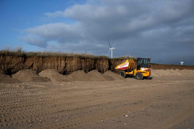 Earth is deposited at the base of cliffs on Fraisthorpe Beach on the North sea coast which are experiencing intense coastal erosion, near Bridlington, in the East Riding of Yorkshire, north eastern England, on November 13, 2025. The Holderness coastline, covering 61km between the Spurn nature reserve in the south and Flamborough in the north, experiences one of the fastest rates of erosion in Europe. The Holderness cliffs are eroding at average rate of around 1.5 metres per year, although individual cliff losses can exceed 20 metres per year. Over the last 1000 years, the coast has retreated by around 2 kilometres, resulting in the destruction of 26 villages listed in the Domesday survey of 1086. (Photo by Oli SCARFF / AFP)