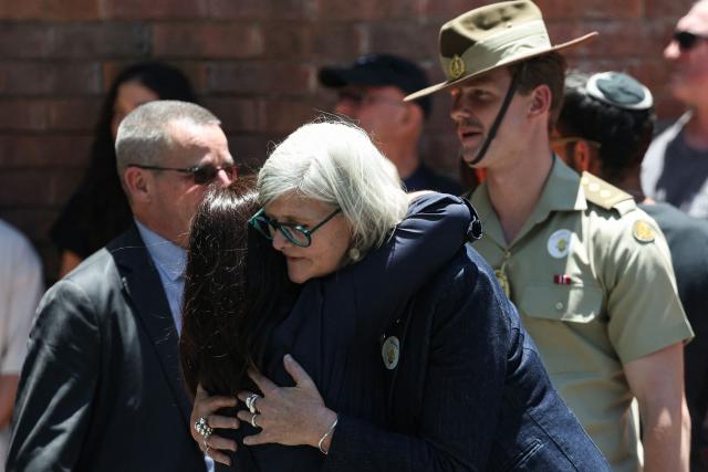 Sam Mostyn (C), Governor-General of Australia, embraces a mourner during the funeral of 10-year-old Matilda, who was killed in the December 14 Bondi Beach shooting attack, in Sydney on December 18, 2025. Australia's Prime Minister Anthony Albanese promised a sweeping crackdown on "hate, division and radicalisation" on December 18 after a mass shooting killed 15 people at a Jewish festival on Bondi Beach. (Photo by DAVID GRAY / AFP)