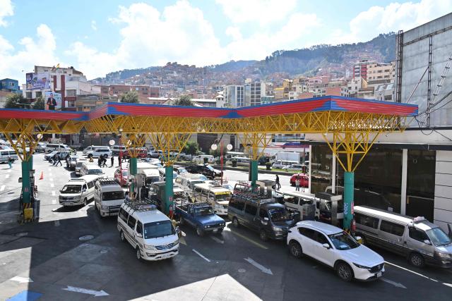 (FILES) Vehicles queue up to get petrol at a service station in El Alto, Bolivia on May 23, 2025. Bolivia's government announced on December 17, 2025, that it will end fuel subsidies, whose prices were frozen during the 20 years of left-wing administrations that preceded it. (Photo by AIZAR RALDES / AFP)