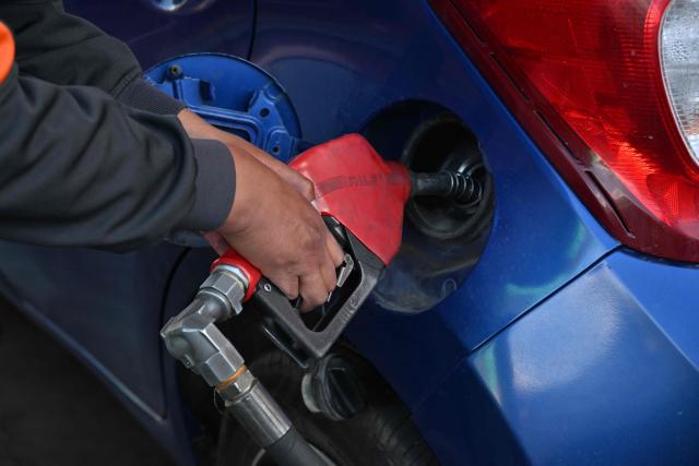 (FILES) A worker fills a vehicle with petrol at a service station in La Paz, Bolivia, on July 31, 2025. Bolivia's government announced on December 17, 2025, that it will end fuel subsidies, whose prices were frozen during the 20 years of left-wing administrations that preceded it. (Photo by AIZAR RALDES / AFP)