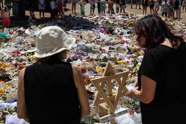 Mourners pay tribute outside Bondi Pavilion in Sydney on December 18, 2025, to honour victims of the Bondi Beach shooting. The attack at Bondi Beach on December 14 was one of the deadliest in Australian history. (Photo by DAVID GRAY / AFP)